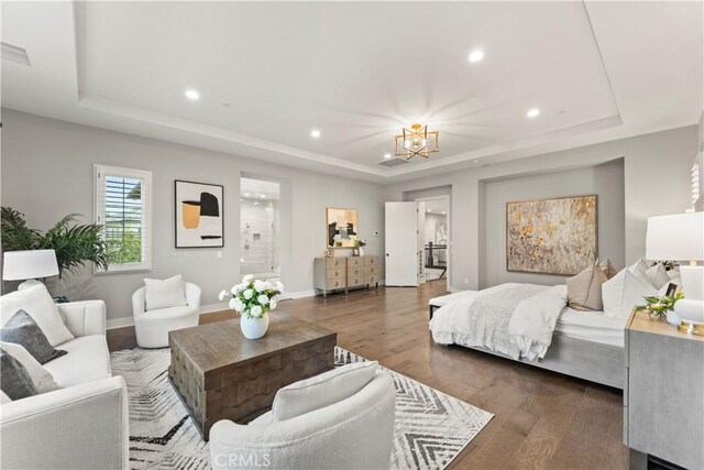 living room featuring a tray ceiling, recessed lighting, wood finished floors, a chandelier, and baseboards