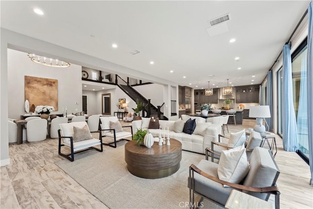 living area featuring recessed lighting, stairs, and a chandelier