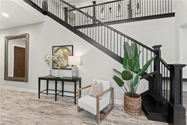 staircase with baseboards, a high ceiling, and recessed lighting