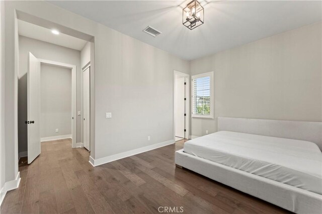 bedroom featuring wood finished floors and baseboards