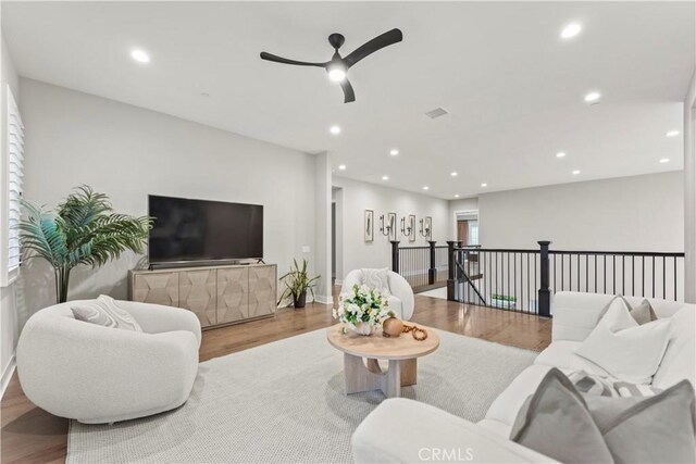 living area with ceiling fan, wood finished floors, recessed lighting, and baseboards