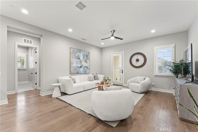 living area with baseboards, wood finished floors, recessed lighting, plenty of natural light, and ceiling fan