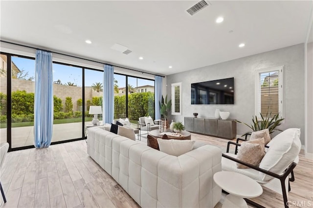 living area featuring light wood-type flooring and recessed lighting
