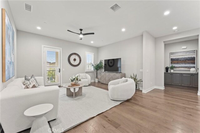 living room with a ceiling fan, wood finished floors, recessed lighting, and baseboards