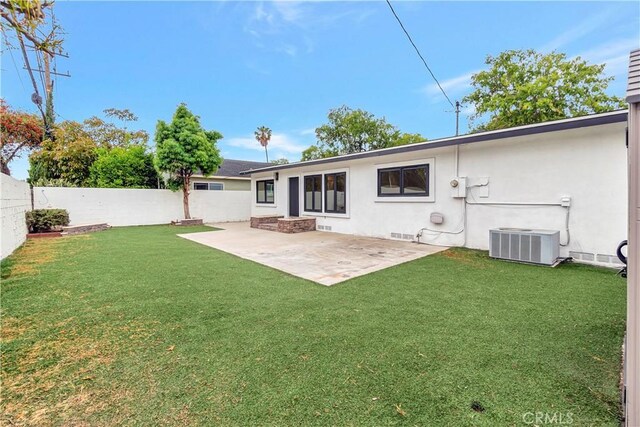 rear view of house with cooling unit, a patio, and stucco siding