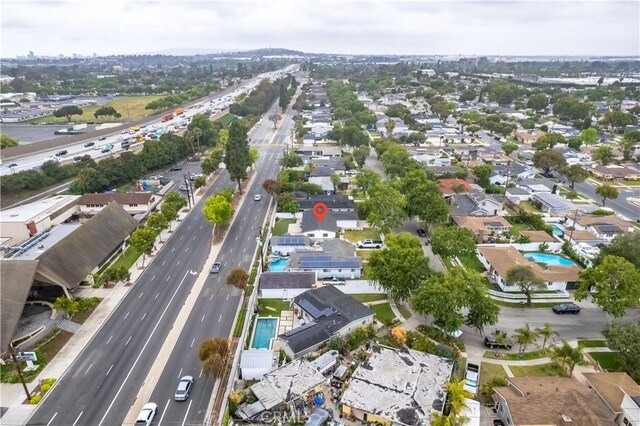 view of property location featuring a major roadway, a pool area, and nearby suburban area