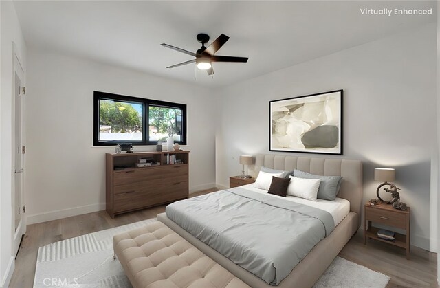 bedroom featuring light wood-style flooring, baseboards, and ceiling fan