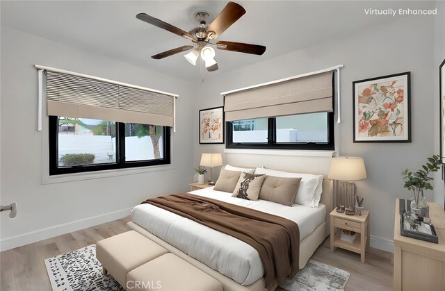 bedroom with light wood-type flooring, baseboards, and a ceiling fan