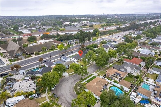aerial view of property's location featuring a pool and nearby suburban area