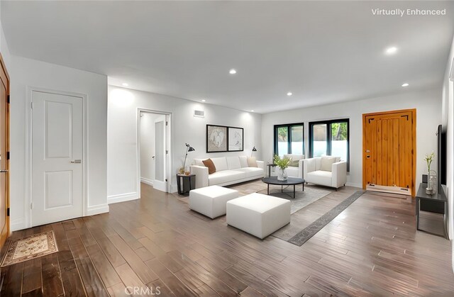 living area with wood finished floors, baseboard heating, baseboards, and recessed lighting