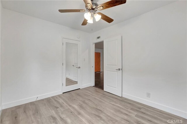 unfurnished bedroom with baseboards, light wood finished floors, and ceiling fan