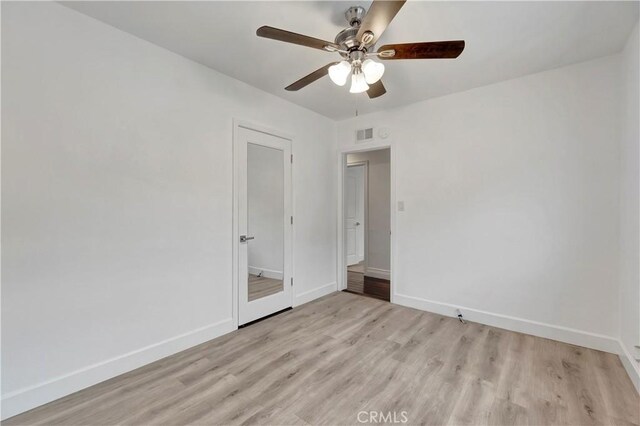 unfurnished bedroom with light wood-type flooring, baseboards, and a ceiling fan