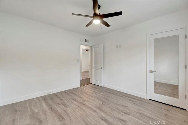 unfurnished bedroom featuring light wood-style flooring, baseboards, and a ceiling fan