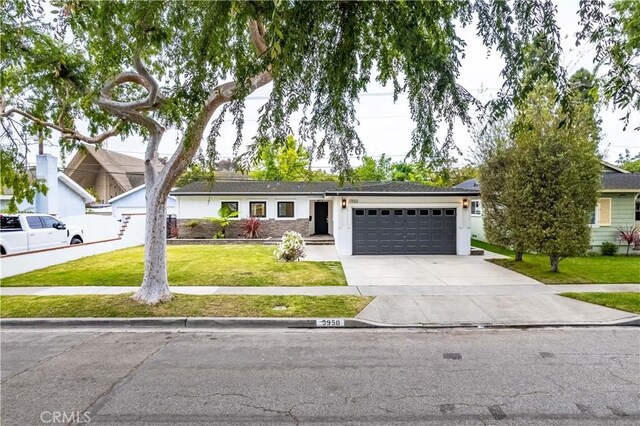 ranch-style house featuring a garage, a front yard, and driveway