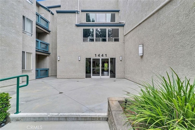 rear view of property with stucco siding and a patio