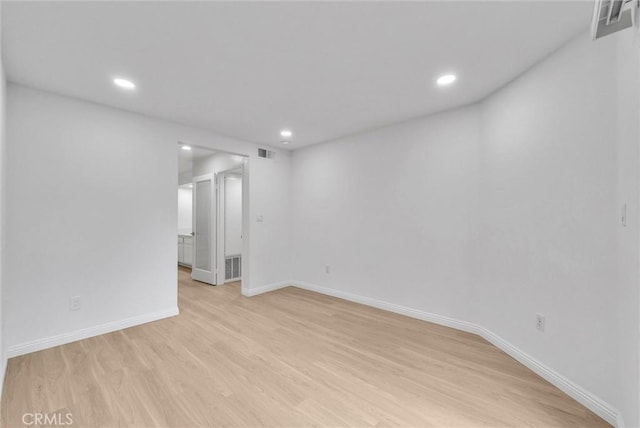 empty room with light wood-style flooring, baseboards, and recessed lighting
