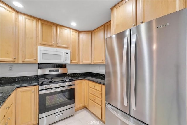 kitchen featuring appliances with stainless steel finishes, light brown cabinetry, recessed lighting, light tile patterned flooring, and dark stone counters