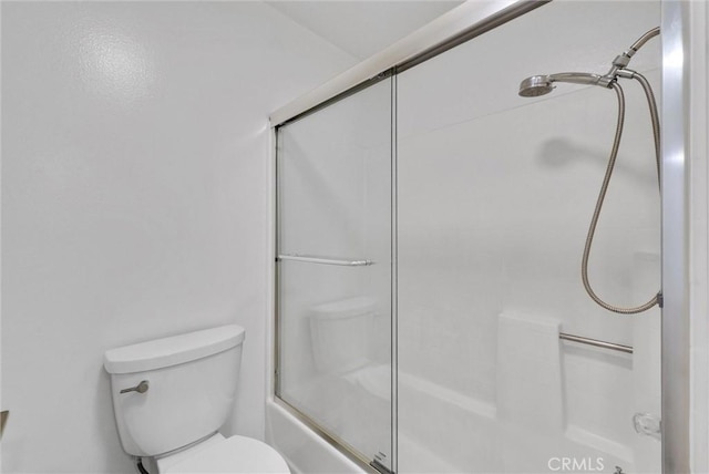 bathroom with a shower with door and toilet