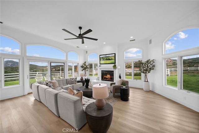 34105 Stage Rd, Temecula, CA 92592 - living room featuring ceiling fan, a glass covered fireplace, light wood-style floors, recessed lighting, and ornamental molding