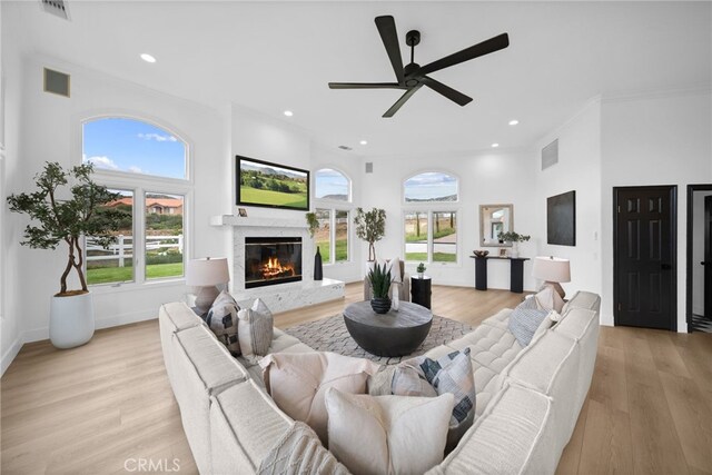 34105 Stage Rd, Temecula, CA 92592 - living area featuring a ceiling fan, a glass covered fireplace, light wood-style floors, recessed lighting, and ornamental molding