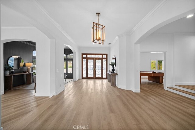 34105 Stage Rd, Temecula, CA 92592 - foyer entrance featuring light wood-style flooring, healthy amount of natural light, arched walkways, ornamental molding, and baseboards