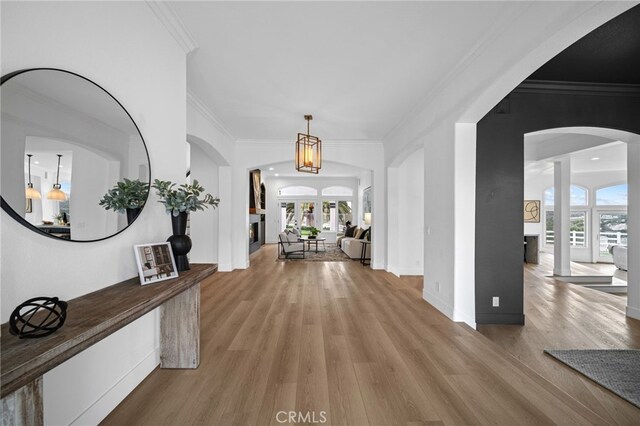 34105 Stage Rd, Temecula, CA 92592 - hallway featuring light wood finished floors, arched walkways, ornamental molding, and baseboards