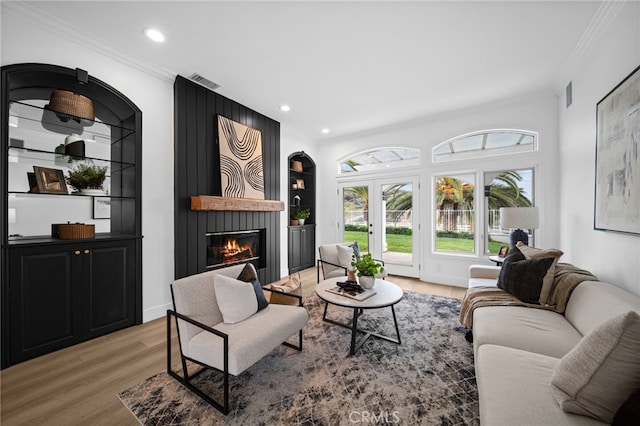 34105 Stage Rd, Temecula, CA 92592 - living area with light wood-style floors, crown molding, a large fireplace, built in shelves, and recessed lighting