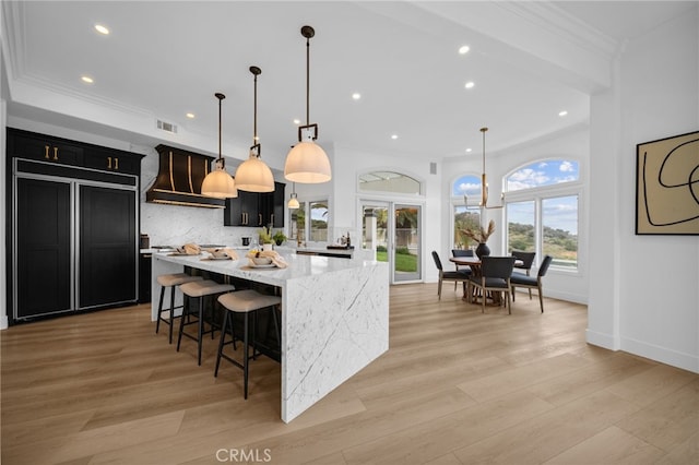 34105 Stage Rd, Temecula, CA 92592 - kitchen with premium range hood, dark cabinetry, recessed lighting, crown molding, and backsplash