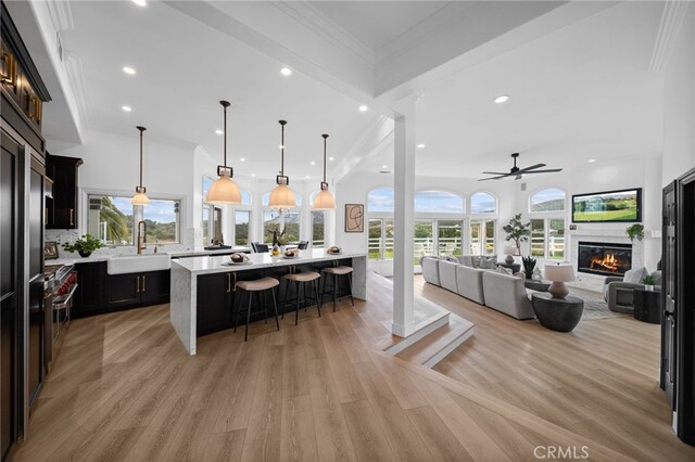 34105 Stage Rd, Temecula, CA 92592 - kitchen with a sink, a breakfast bar area, light countertops, ceiling fan, and a glass covered fireplace