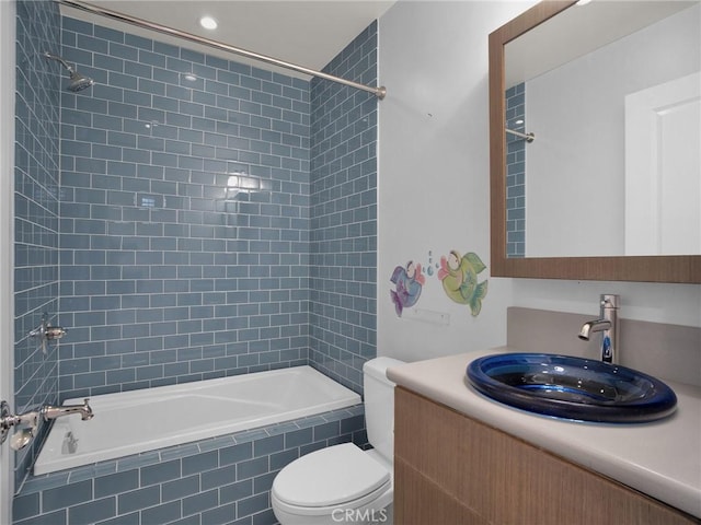 bathroom with tiled shower / bath, toilet, vanity, and recessed lighting