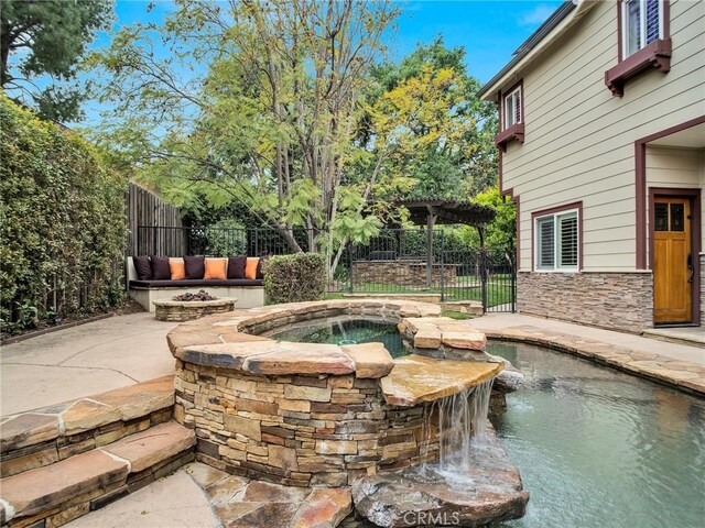 view of swimming pool with an in-ground hot tub and a fenced backyard