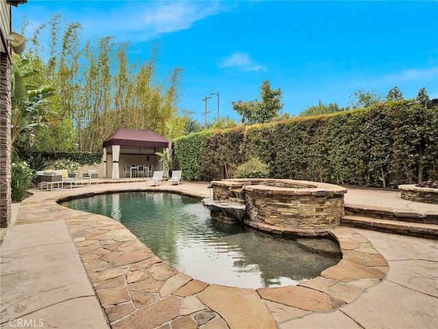 view of swimming pool with a patio area, a fenced backyard, and a pool with connected hot tub