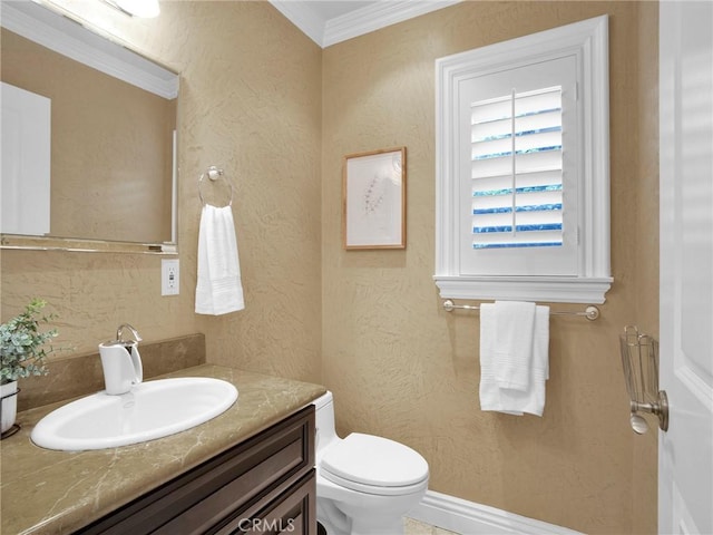 bathroom featuring toilet, crown molding, vanity, and a textured wall