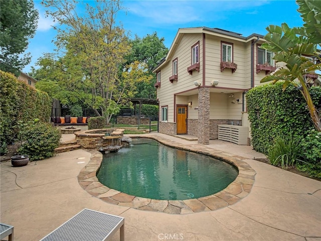 view of swimming pool featuring an outdoor fire pit, a patio area, a pool with connected hot tub, and fence