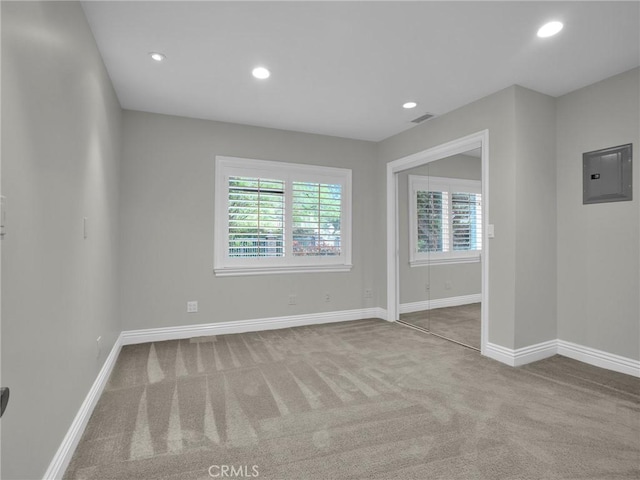 carpeted empty room featuring electric panel, baseboards, and recessed lighting