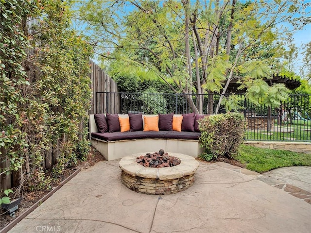 view of patio featuring fence and a fire pit