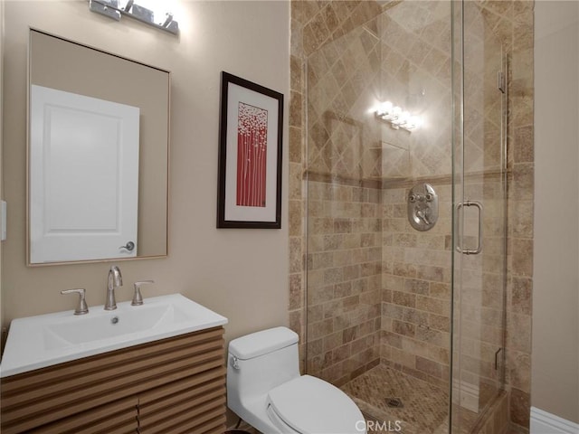 bathroom featuring a stall shower, toilet, and vanity