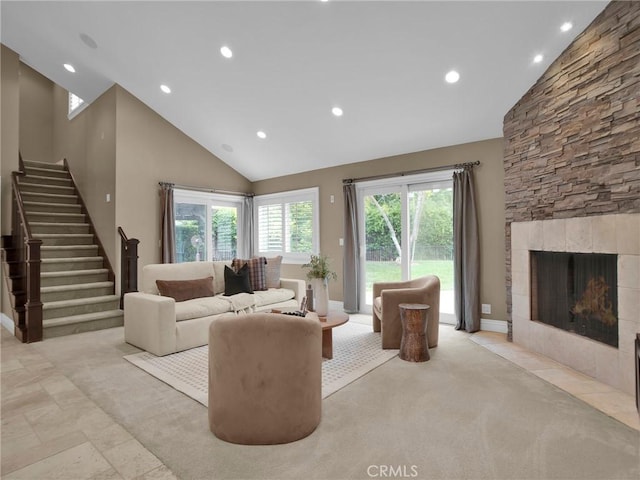 living room featuring recessed lighting, stairs, high vaulted ceiling, a stone fireplace, and baseboards