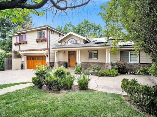 view of front facade featuring concrete driveway, an attached garage, roof mounted solar panels, stone siding, and a front yard