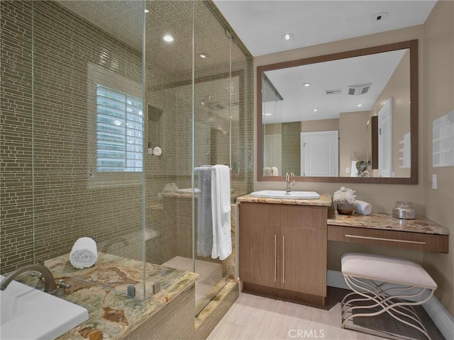 full bath featuring a stall shower, vanity, recessed lighting, and tile walls