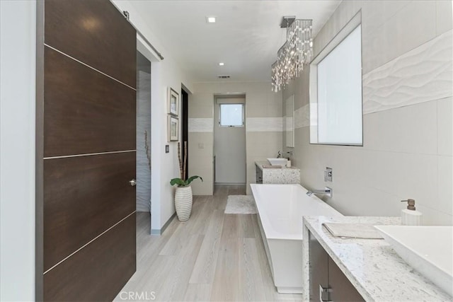 29 W Neapolitan Ln, Long Beach, CA 90803 - full bathroom with a soaking tub, vanity, wood finished floors, a chandelier, and tile walls