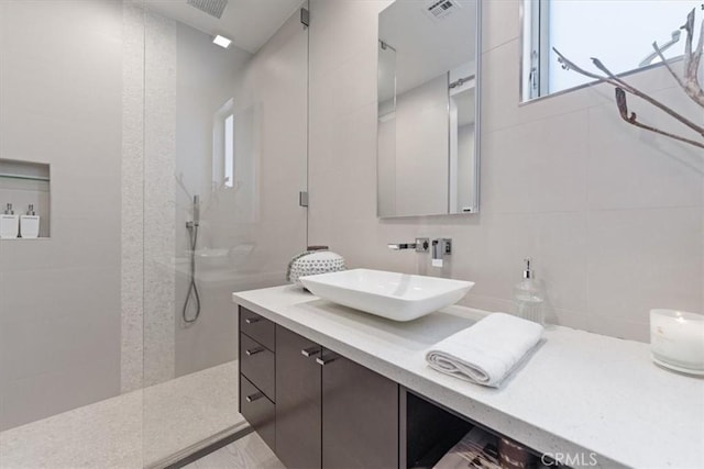 29 W Neapolitan Ln, Long Beach, CA 90803 - bathroom with a walk in shower, vanity, tile walls, healthy amount of natural light, and tasteful backsplash