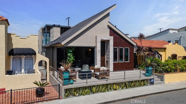 29 W Neapolitan Ln, Long Beach, CA 90803 - rear view of property featuring stucco siding, a fenced front yard, and stone siding