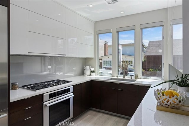 29 W Neapolitan Ln, Long Beach, CA 90803 - kitchen featuring appliances with stainless steel finishes, modern cabinets, white cabinetry, and dark brown cabinetry