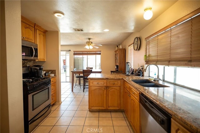 13117 Pan Am Blvd, Moreno Valley, CA 92553 - kitchen featuring appliances with stainless steel finishes, a sink, light tile patterned floors, a ceiling fan, and light stone countertops