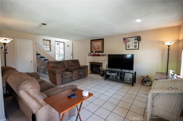 13117 Pan Am Blvd, Moreno Valley, CA 92553 - living room with stairs, a textured ceiling, light tile patterned floors, and a fireplace