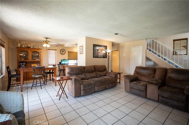13117 Pan Am Blvd, Moreno Valley, CA 92553 - living area featuring light tile patterned flooring, stairs, a textured ceiling, and a ceiling fan