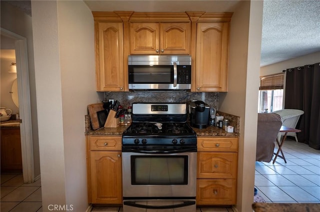 13117 Pan Am Blvd, Moreno Valley, CA 92553 - kitchen with stainless steel appliances, decorative backsplash, light tile patterned floors, and dark stone countertops