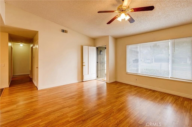 23719 White Owl Ct, Moreno Valley, CA 92553 - empty room with a textured ceiling, light wood-style floors, ceiling fan, vaulted ceiling, and baseboards