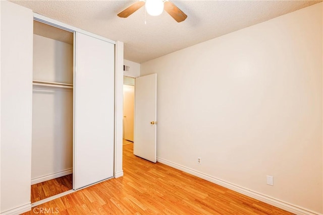 23719 White Owl Ct, Moreno Valley, CA 92553 - unfurnished bedroom with light wood-style floors, a closet, baseboards, ceiling fan, and a textured ceiling